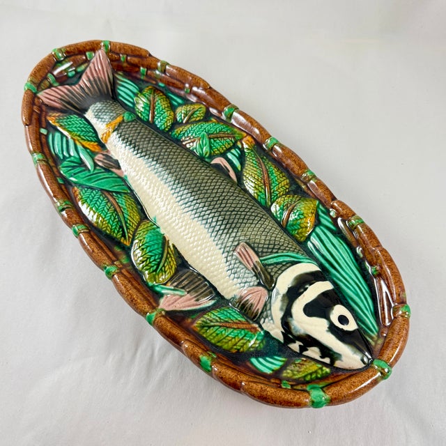From the Mid-Century era, a Majolica glazed ceramic wall plaque showing a Fish in a Basket. Styled after an antique...