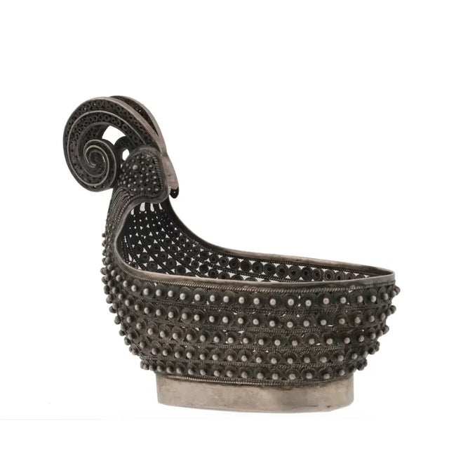 A Russian silver kovsh decorated throughout the body with pointed scrolling filigree patterns and a curved horn-like...
