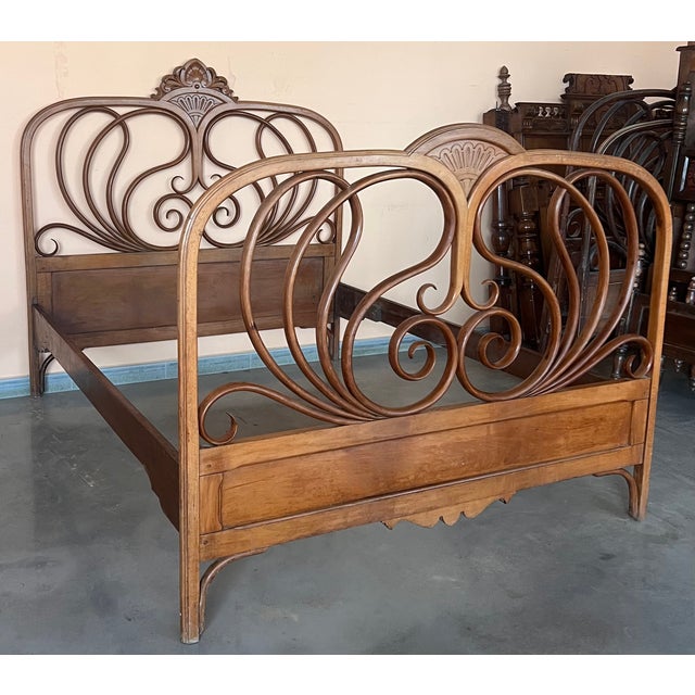 Designed by J & J Kohn, this mahogany stained bentwood bed features curved head and footboards swelling with decorative...