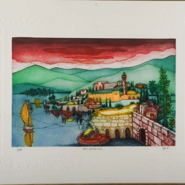 This Framed Signed Amram Ebgi "Sea of Galilee" Colored Etching Artist Proof presents a vivid interpretation of the...