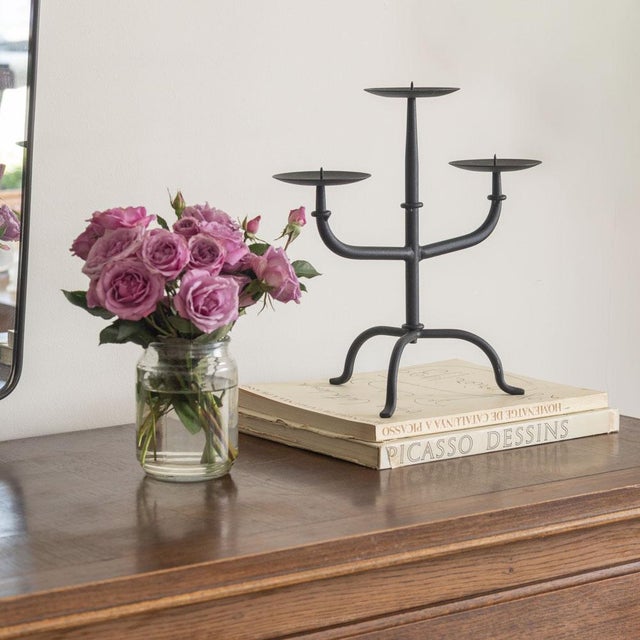 Vintage iron three arm candelabra from France. Thin curved arms on a three leg iron base. Original finish shows nice age...