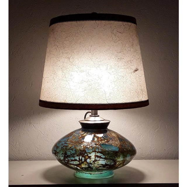 Art Deco table lamp with an internally illuminated colored glass base with a rounded base, a part silver plated brass...