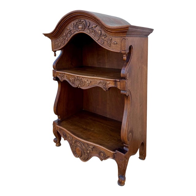 Charming Spanish open shelf crafted from wood, featuring an elegant curved top and beautifully carved floral decorations....