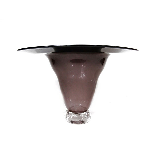 Striking amethyst crystal glass footed vase with a wide flared rim, smoky purple body, and clear heavy foot. The piece has...