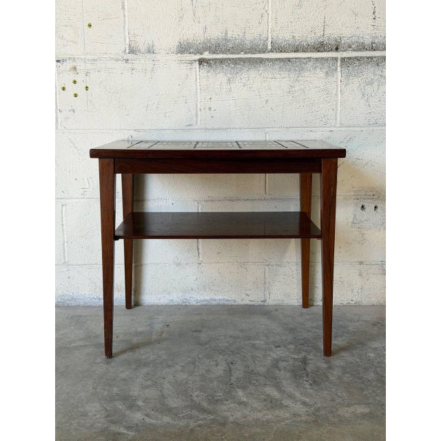 This rectangular coffee table features clean lines and a functional two-tier profile. The inset surface showcases a...