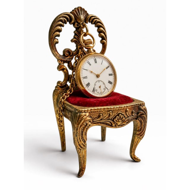 Charming miniature brass chair designed as a pocket watch display stand, featuring an elaborately pierced and scrolling...