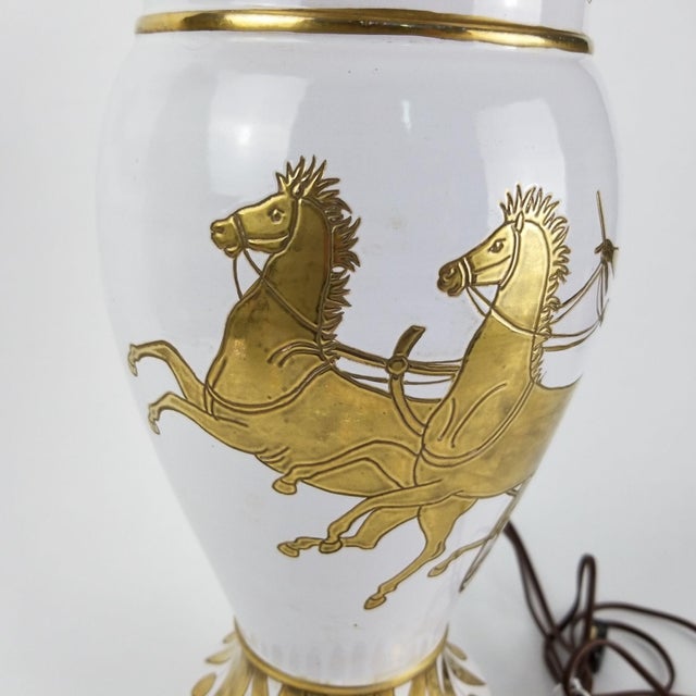 A white & gold vintage Stiffel lamp. It's tall, elegant & depicting a classical chariot driver with 2 rearing horses. It...