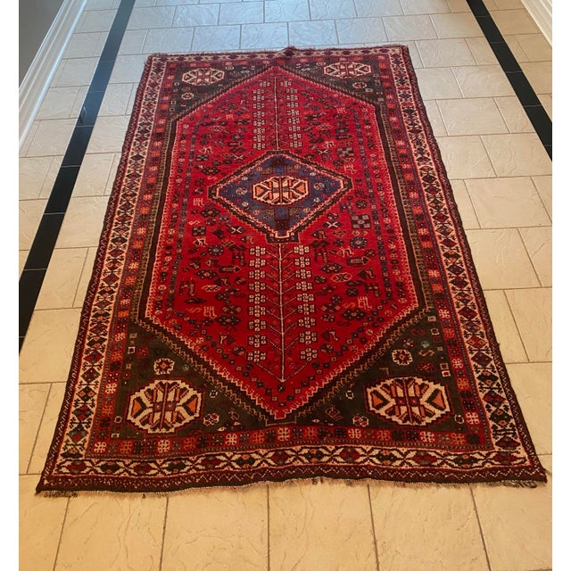 A Persian (Iranian) Shiraz wool hand-knitted rug from the mid-20th century with a tribal geometric design. It would be...