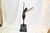 A topless dancer in Egyptian style dress in a dance pose. Hi cast bronze with fine details and multi patina finish....