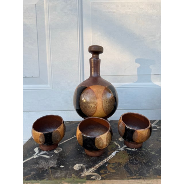 This is a vintage decanter and cup set attributed to designer Robert Maxwell for Pottery Craft USA. Mid-century modern in...