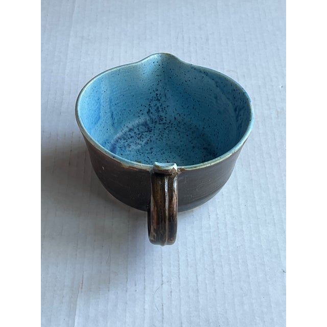 A blue and brown handles cup/gravy boat. Perfect for making small batch eggs, glaze, butter sauce, dressing and gravy....