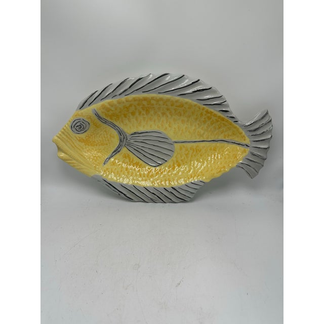 This is a ceramic fish-shaped platter, playful yet refined in its design. Front • Shape: The platter is molded in the form...
