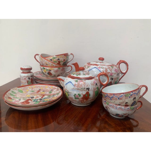 Japanese set of china in red, Kutani style, also called “geishaware”. Eggshell porcelain finely decorated with landscapes...