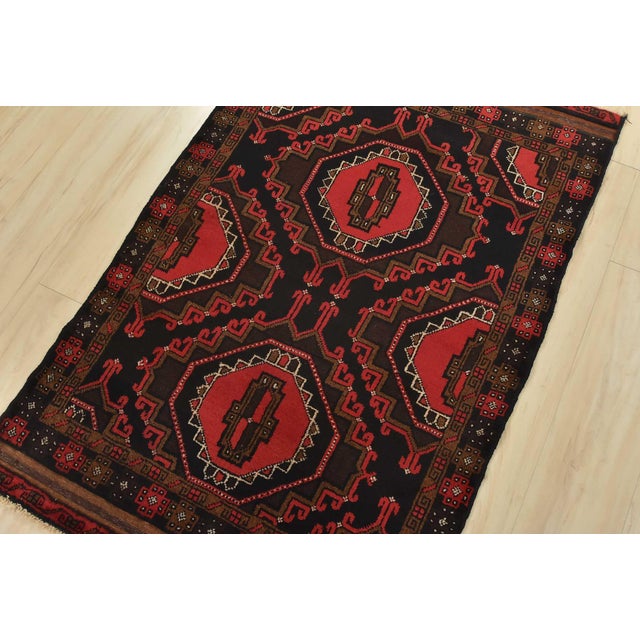 This authentic vintage, tribal, geometric Baloch rug is hand-knotted with an all-wool pile on a wool foundation. This rug...
