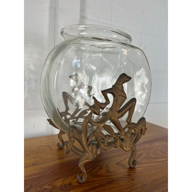 An artistic art deco fishbowl crafted from gilt cast iron and topped with a rounded glass bowl. The base features...
