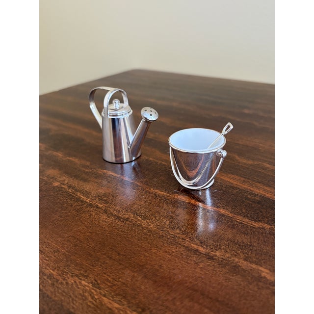 A charming pair of French Country style silver plate salt & pepper shakers in the form of a garden pail with shovel and a...