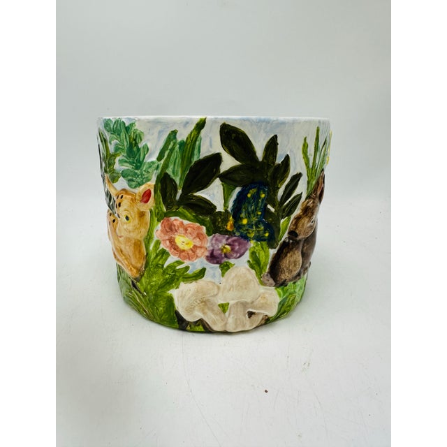 This is a ceramic woodland-themed planter with raised (relief) decoration. It’s a round, slightly tapered pot featuring...