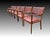 The chairs are of teak wood and upholstered with deeper shade of red leather. signs of use and wear are present, sturdy...