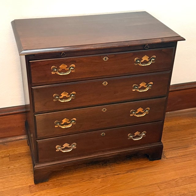 Late 20th century mahogany bachelor chest in the Chippendale style. A pull out brushing slide sits under the molded top....