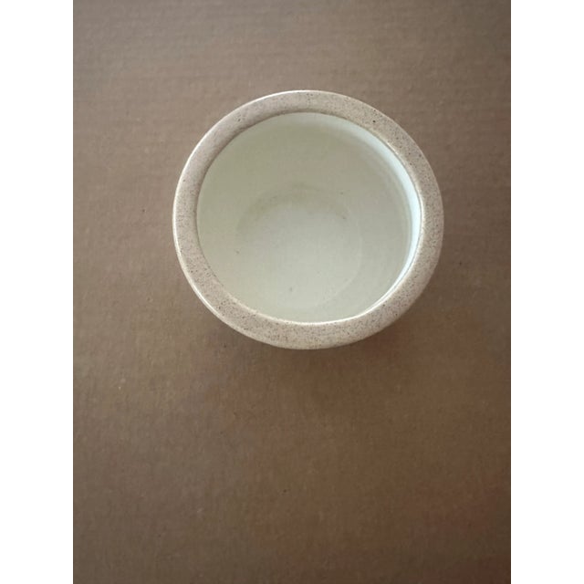 Elegant and understated, this small handmade studio pottery bowl features a softly ridged texture and a warm natural...