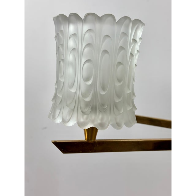 Vintage 1960s chandelier. Gold and black metal frame with eight frosted, sculpted glass lights. Height 58 cm Length 80 cm...