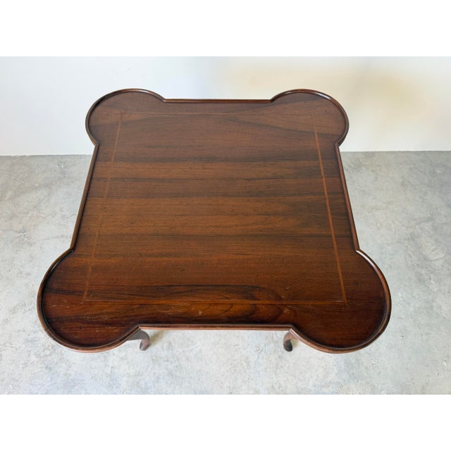 Elegant vintage Italian game table featuring a distinctive quatrefoil-shaped top with rounded corners, warm walnut-toned...