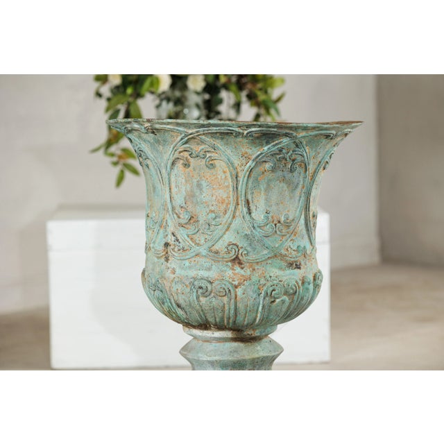 This large bronze urn displays a commanding presence with its classical profile and richly textured surface. The piece is...