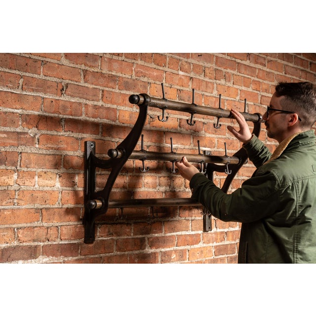 Substantial wall-mounted coat rack in a classic two-tier "firehouse" configuration, featuring turned wooden rails...