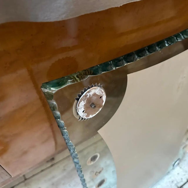 This 1950s Mid-Century Modern Verde Nilo Glass and Brass Wall Mirror by Cristal Arte is a beautiful and elegant decorative...