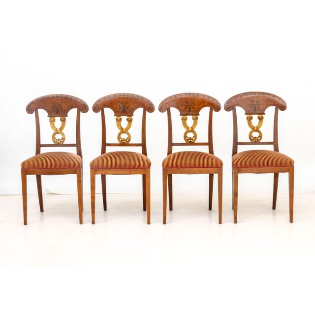 Set of Four Russian Style Birch and Parcel Gilt Dining Chairs, each with ebonized floral motif and pierced back splat with...