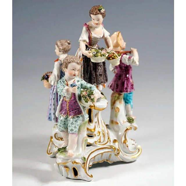 Meissen porcelain group from the time of origin: four children in festive, rural rococo clothing on a three-part rocaille...