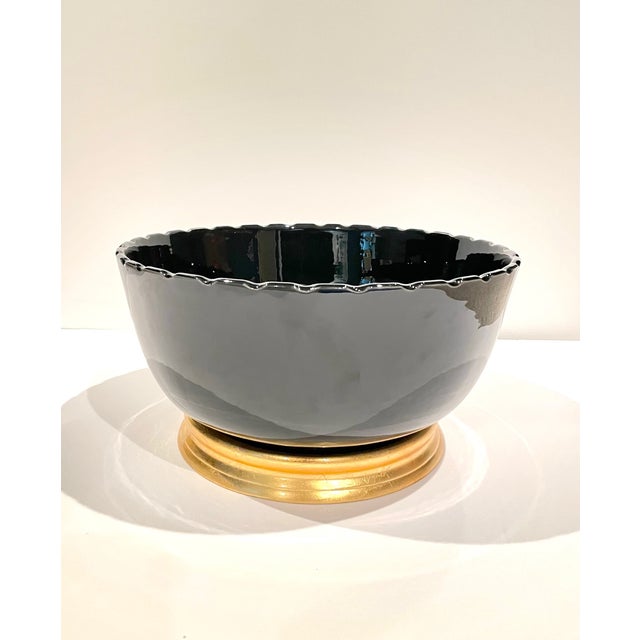 Contemporary decorative bowl with chinoiserie style. It is in glossy black with scallop edges. It comes with a gold leaf...