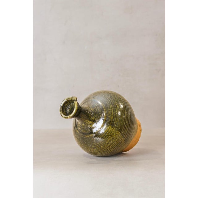 Unearth the past with this antique Asian rice wine glazed clay container, a testament to the craftsmanship of a bygone...
