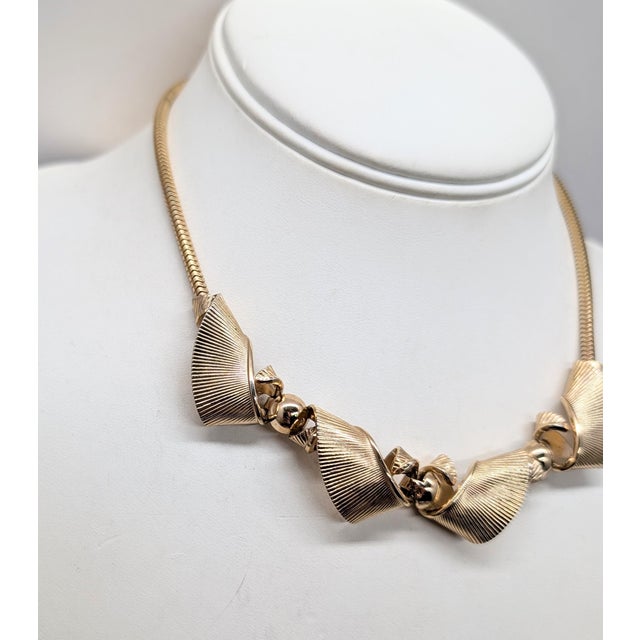 1950s goldtone ridged curled "ribbon" links on a snake chain necklace with hook clasp. Marked "NAPIER" on the hook....