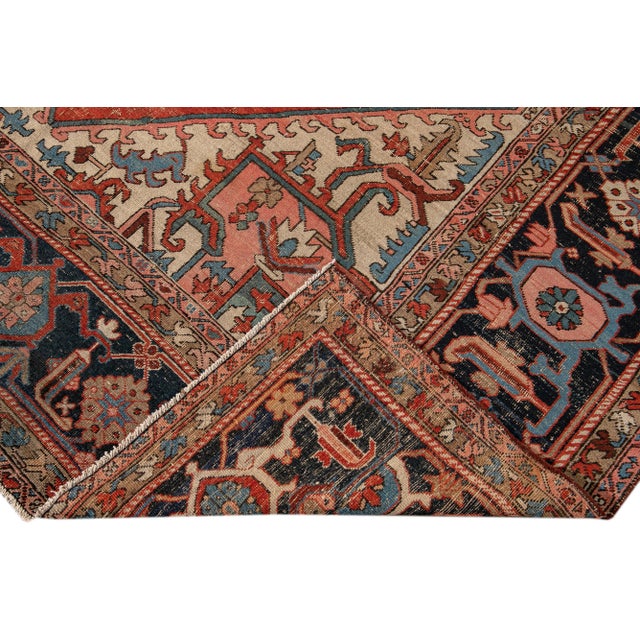 Beautiful antique Persian Serapi hand-knotted wool rug with a red and ivory field. This Heriz rug has a blue frame and...