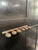 This black hand painted vintage European hallway rack includes 6 brass hooks under a ladder shelf along the top. There is...