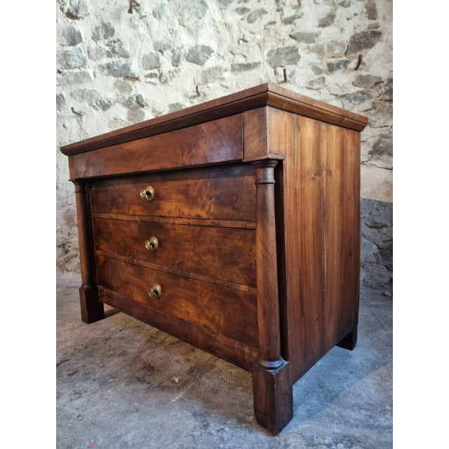 This French commode dates from the early 19th century (circa 1800–1830) and is crafted from solid walnut with walnut...