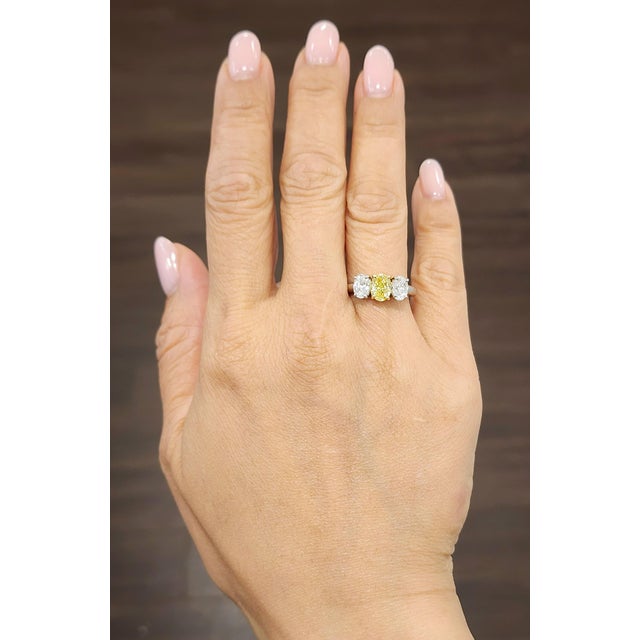 This stunning 2.21-carat three-stone yellow and white diamond ring is the perfect addition to any jewelry collection. The...