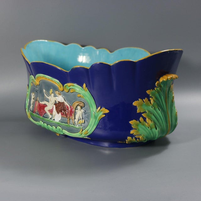 A Minton majolica jardinière with a mythological theme, decorated in the firm’s blue ground colourway and richly modelled...