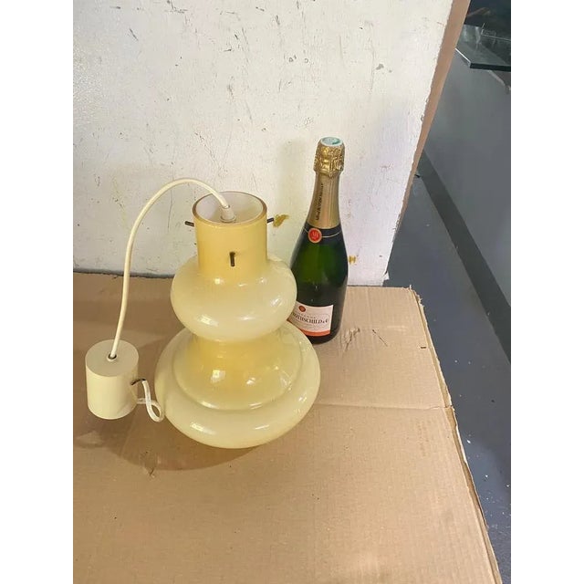 This vase is made in glass in Oplaline. It has been made in Italy in the 1970's. It is a beige color. Up to 250V...
