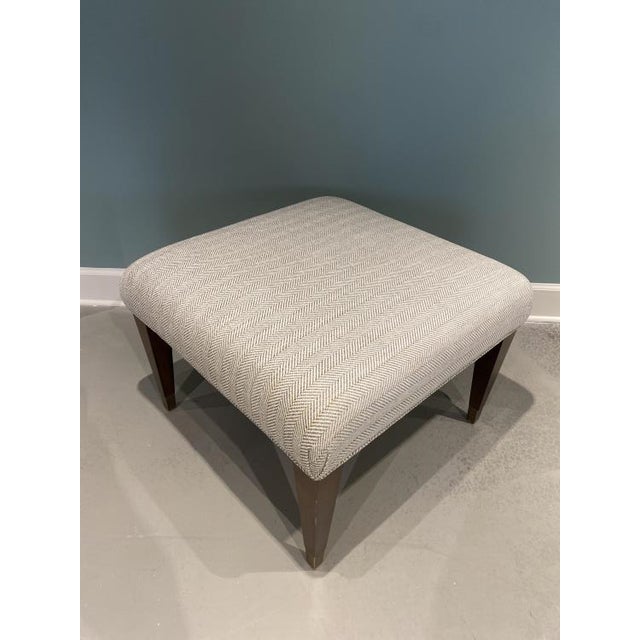 The Century Bench is a first quality sample that features a Taupe fabric with a walnut finish.