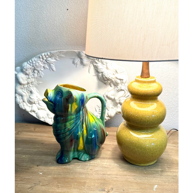 Fun dig glaze water pitcher. It is 11” tall. It’s in Good condition you can see a few missing glaze spots but no chips or...
