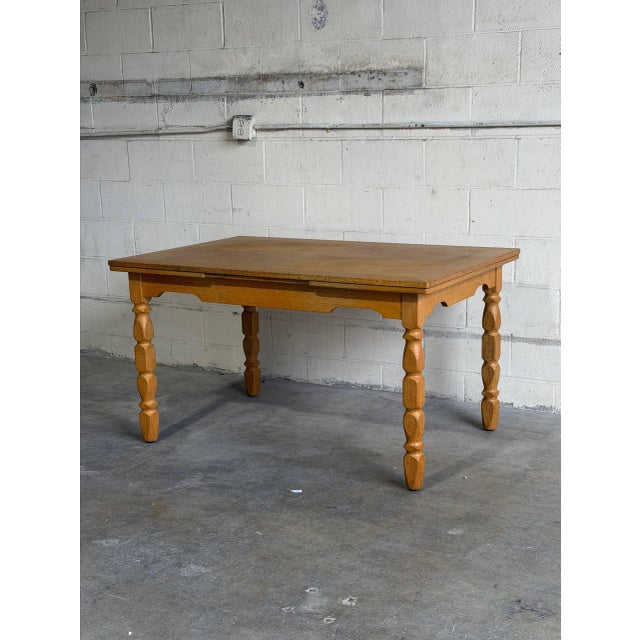 Danish draw leaf dining table designed by Henning Kjærnulf and crafted in solid oak. This elegant Scandinavian table...