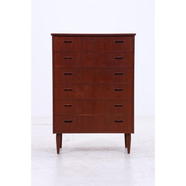 Vintage teak tallboy chest with six spacious drawers and a slim silhouette. The integrated recessed handles, beautiful...