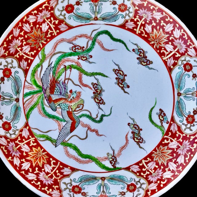 This Japanese Imari porcelain charger plate, characteristic of Arita ware from the Meiji period, features a detailed hand-...