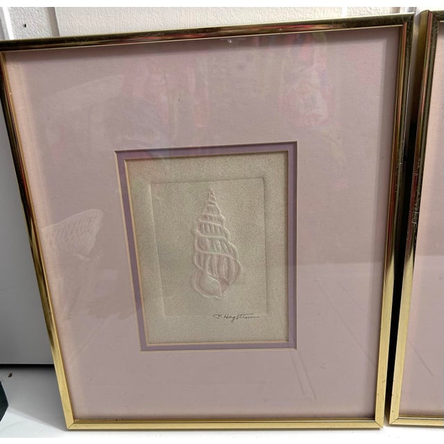 Highly collectible, minimalist coastal pieces display relief-embossed shells mounted on characteristic pink and gold...