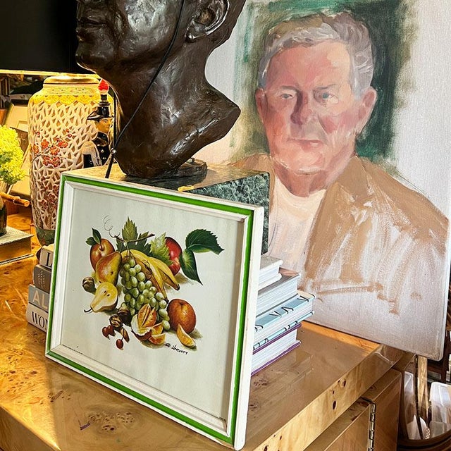 A bright still-life print of fruit in a bright green and white frame. This piece would look great on a shelf in a kitchen...