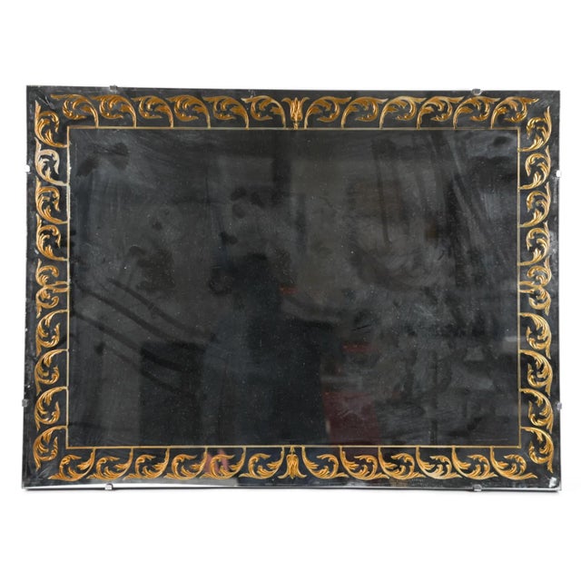 A vintage mid-century rectangular wall mirror in the églomisé style, with a wide border of reverse-painted and gilded...