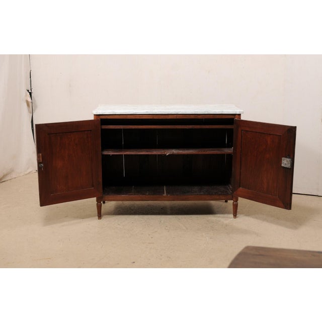 A French two-door chest, with it's original marble top, from the early 19th century. This antique chest from France...