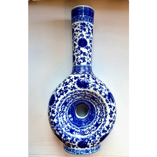 An unusual blue and white porcelain vase with a donut hole center. Signed on base.
